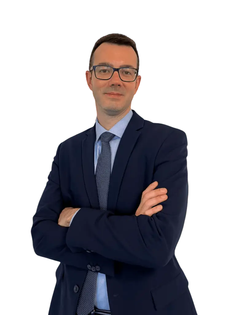 Professionista della consulenza patrimoniale in abito, in posa formale con braccia incrociate su sfondo neutro.